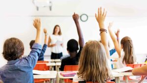 Kids raising hands in classroom